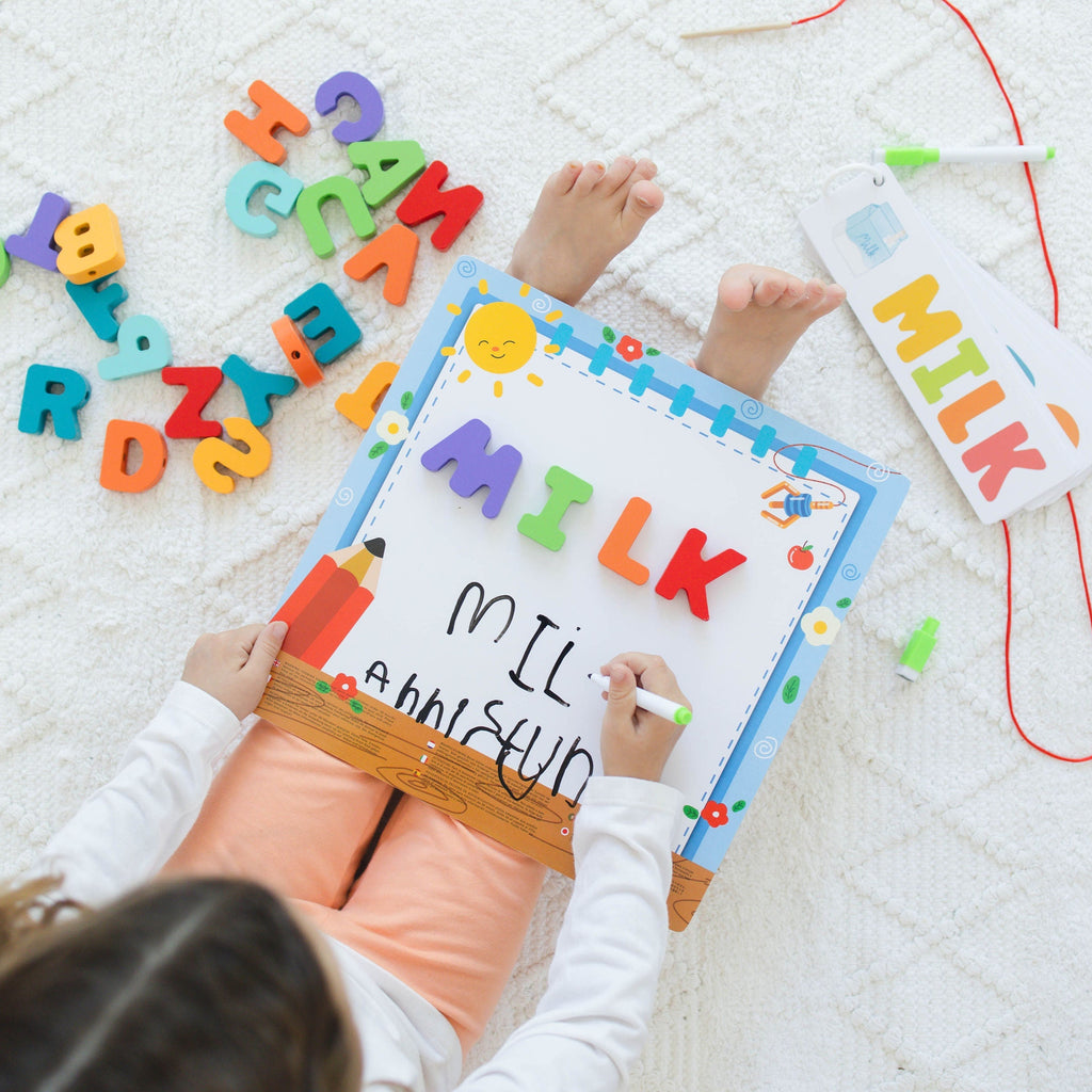 Child playing with colorful letters and a sign on a white surface
