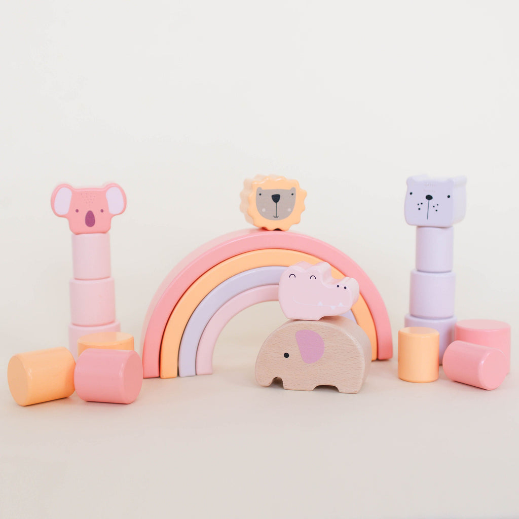 Set of colorful wooden toys including a rainbow, animals, and blocks on a light background