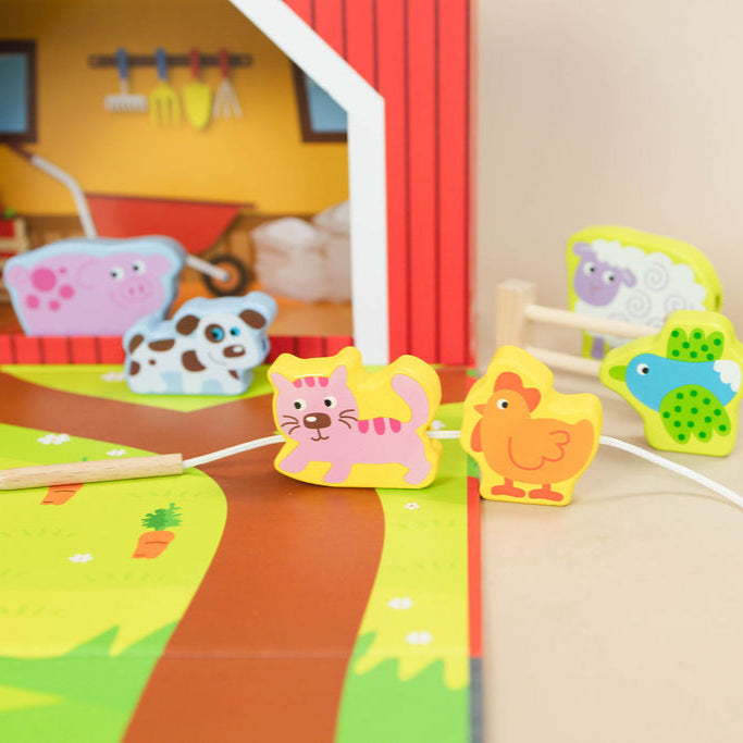 Colorful animal-themed playset with a small barn and animals in the background.