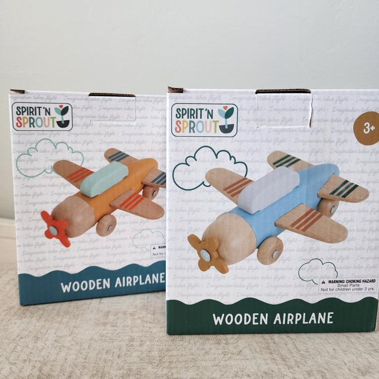 Two boxes of Spirit 'N Sprout wooden airplanes on a neutral background