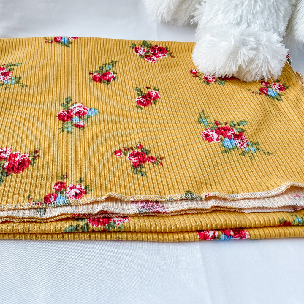 Yellow fabric with floral patterns on a white background